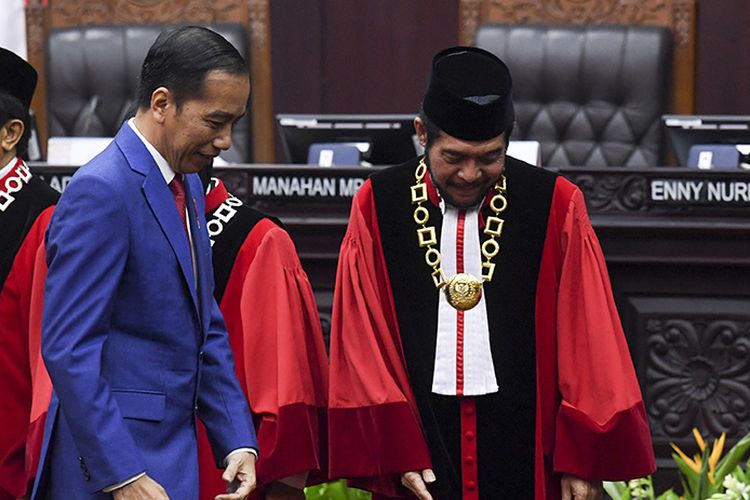 Presiden Joko Widodo (kiri) bersiap mengikuti foto bersama dengan Ketua Mahkamah Konstitusi (MK) Anwar Usman seusai sidang pleno penyampaian laporan tahun 2019 di Gedung MK, Jakarta, Selasa (28/1/2020). Sejak berdiri pada tahun 2003 hingga Desember 2019 MK telah menerima sebanyak 3.005 perkara.