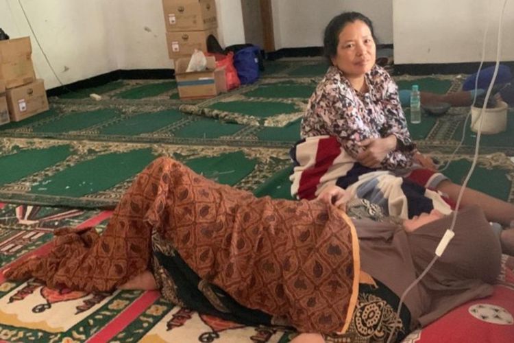 Seorang warga di Kabupaten Cianjur. Jawa Barat menjalani penanganan medis di tempat usai mengalami gejala keracunan, Senin (2/10/2023). Sebanyak 78 warga diduga keracunan makanan usai menyantap nasi kotak.