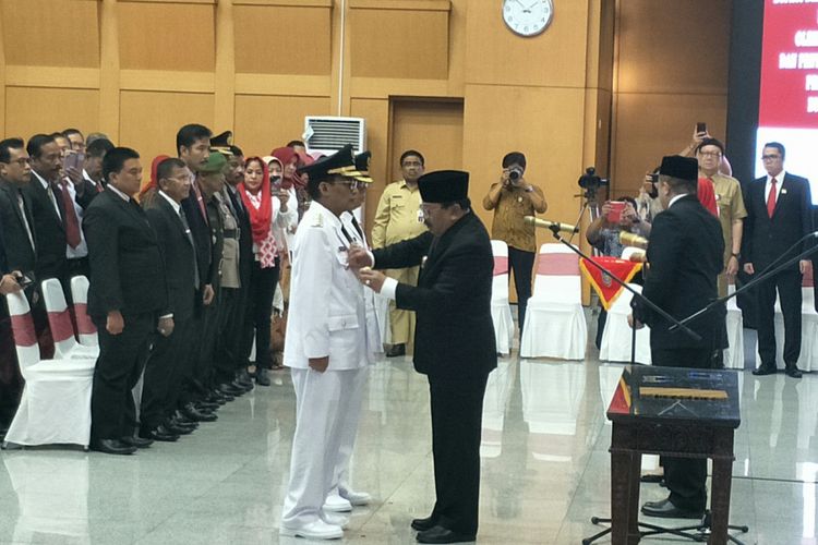 Gubernur Jawa Timur Soekarwo memasangkan lencana kepada Bupati Tulungagung Syahri Mulyo di Kantor Kementerian Dalam Negeri, Jakarta, Selasa (25/9/2018)