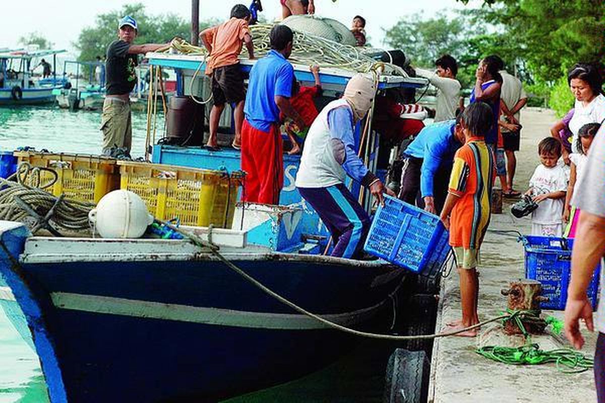 Sejumlah warga dan wisatawan di Pulau Pramuka, Kepulauan Seribu, Sabtu (11/6), menyaksikan nelayan setempat menurunkan hasil tangkapan ke tempat pelelangan ikan. Penghasilan nelayan belakangan ini kian menurun, salah satunya karena faktor cuaca buruk yang membuat frekuensi melaut makin menurun.