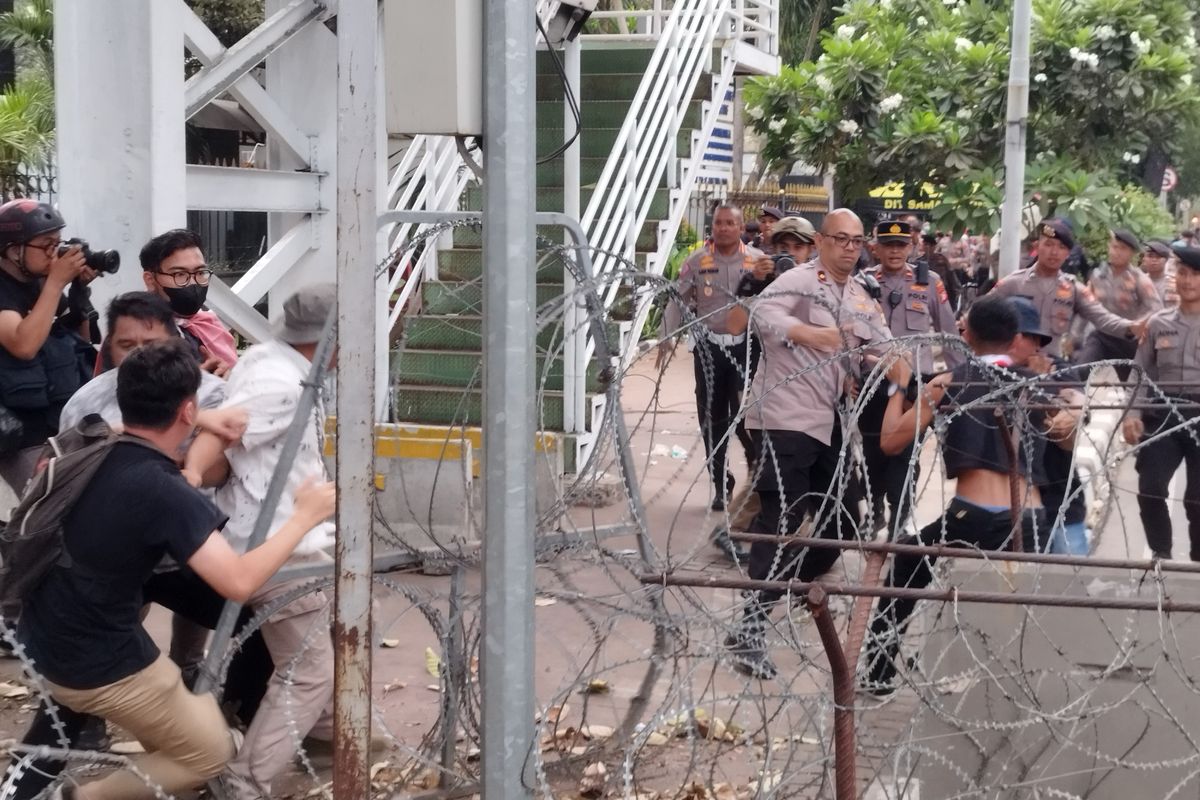 Tiga mahasiswa ditangkap polisi usai menerobos kawat berduri di Jalan Medan Merdeka Barat, Gambir, Jakarta Pusat, Jumat (20/10/2023). (KOMPAS.com/XENA OLIVIA)