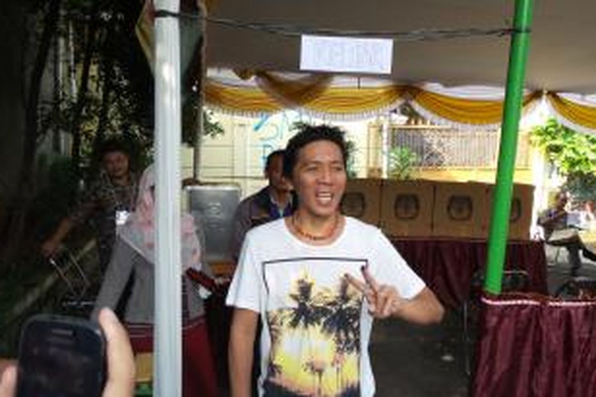 Pemain drum Slank, Bimo Setiawan Almachzumi alias Bimbim, mengacungkan Salam 2 Jari usai menggunakan hak pilihnya di TPS 15, Kelurahan Duren Tiga, Pancoran, Jakarta Selatan, Rabu (9/7/2014).