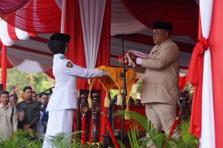 Nayla Aprilia (16), siswi kelas XI Madrasah Aliyah Negeri (MAN) 1 Kabupaten Bogor sebagai pembawa baki bendera pusaka pada upacara peringatan HUT ke-80 Kemerdekaan Republik Indonesia di Lapangan Tegar Beriman, Cibinong, Minggu (17/8/2025). Ia pernah menempuh pendidikan di Pesantren Nurul Ilmi Cibinong.