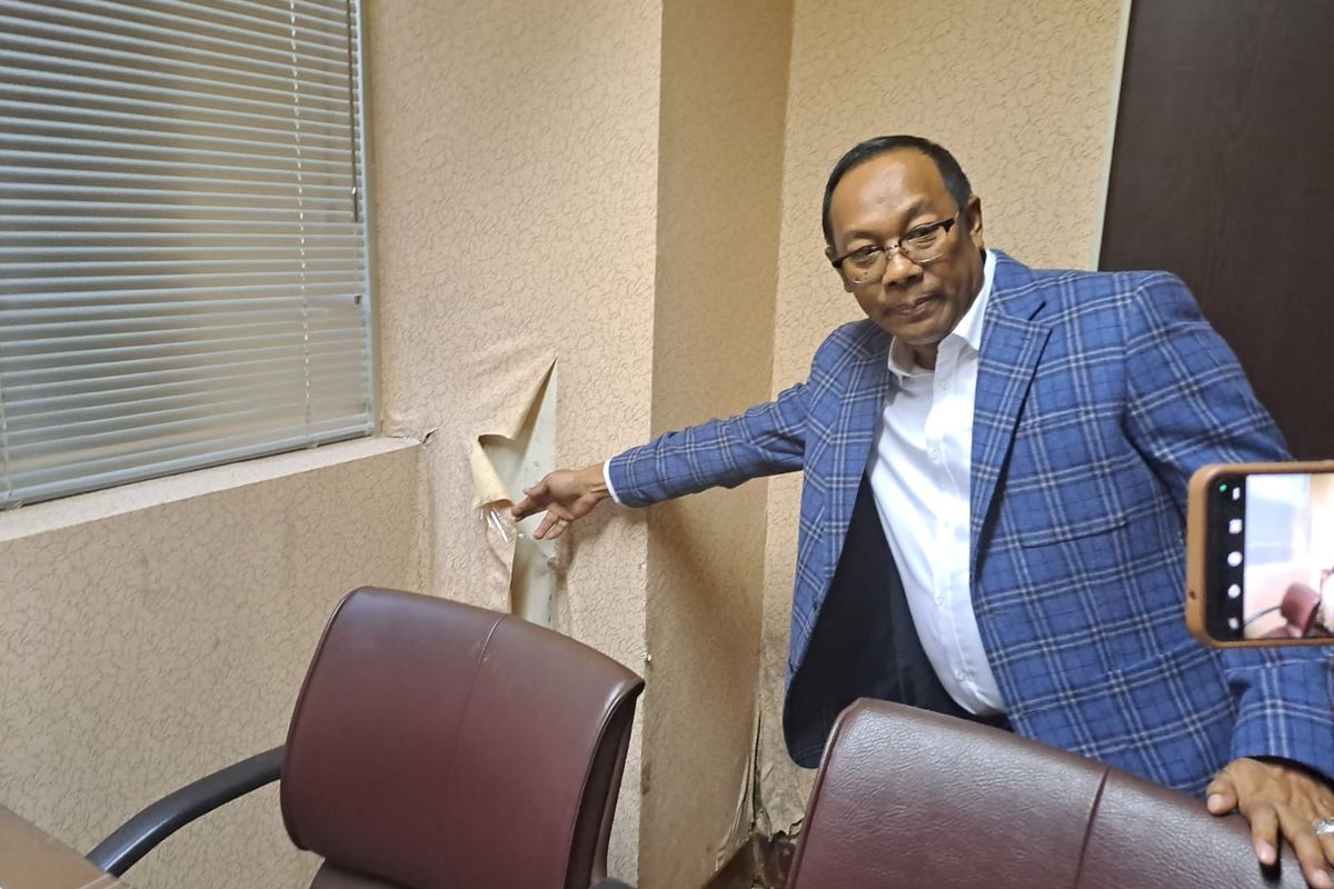 Sekjen DPD Rahman Hadi menunjukkan wallpaper di dinding ruang kerja anggota DPD yang sudah mulai terkelupas, Gedung DPD, Senayan, Jakarta, Kamis (8/6/2023). 