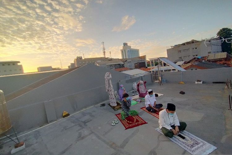  Sejumlah perantau yang tinggal di Gang Kelinci, Pasar Baru, Jakarta Pusat, melaksanakan Shalat Idul Fitri 1441 Hijriyah di teras atap rumah (roof top), Mingggu (24/5/2020). 
