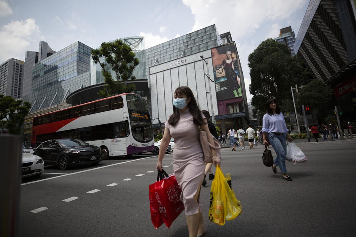 Orang-orang berjalan memakai masker di Orchard Road, Singapura (12/3/2020), sebagai tindakan pencegahan agar tidak tertular virus corona.