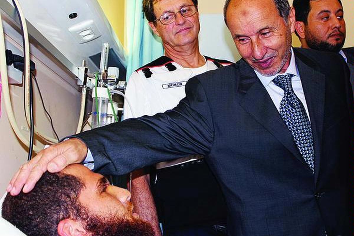 Dewan  Transisi Nasional  (NTC), yang diwakili Mustafa Abdel Jalil (kanan), berbicara dengan   korban dalam kunjungannya ke  rumah sakit bersama delegasi medis Perancis, di sebelah timur  kota Benghazi, Sabtu (22/10).  