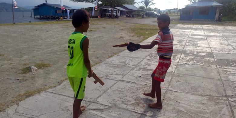 Kiri-kanan: Titus (11) dan Mulanya Yulius (11), dua bocah Papua yang asyik bermain pistol-pistolan dari kayu di danau Sentani, Jayapura, Selasa (27/9/2016).