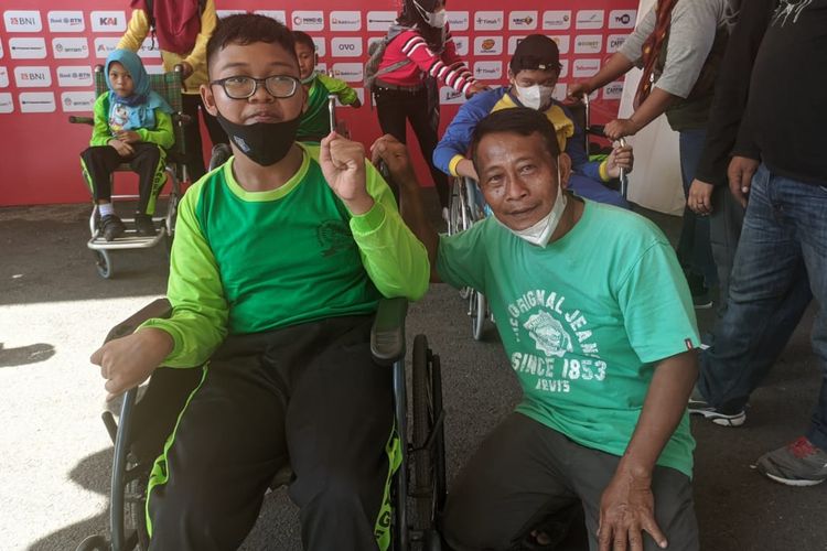 Didik Nazar Pamungkas (kiri) bersama sang ayah saat menonton langsung pertandingan atletik ASEAN Para Games 2022 yang digelar di Stadion Manahan, Solo, pada Kamis (4/8/2022).