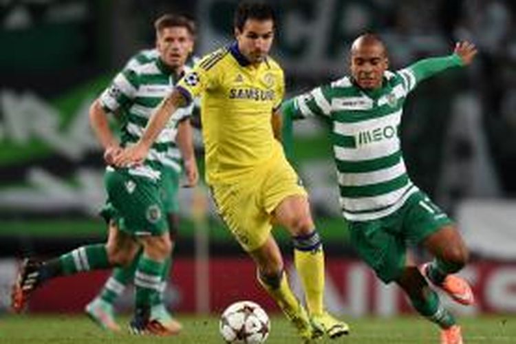 Gelandang Chelsea, Cecs Fabregas, saat berusaha lepas dari kawalan pemain Sporting Lisbon pada matchday kedua Grup G Liga Champions di Stadion José Alvalade, Selasa (30/9/2014). 