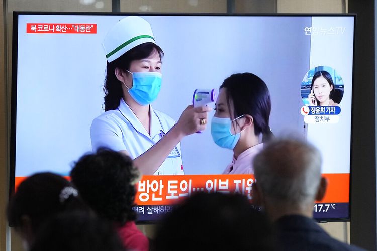 Orang-orang menonton layar TV yang menampilkan laporan berita tentang wabah COVID-19 di Korea Utara, di stasiun kereta api di Seoul, Korea Selatan, Sabtu, 14 Mei 2022. 