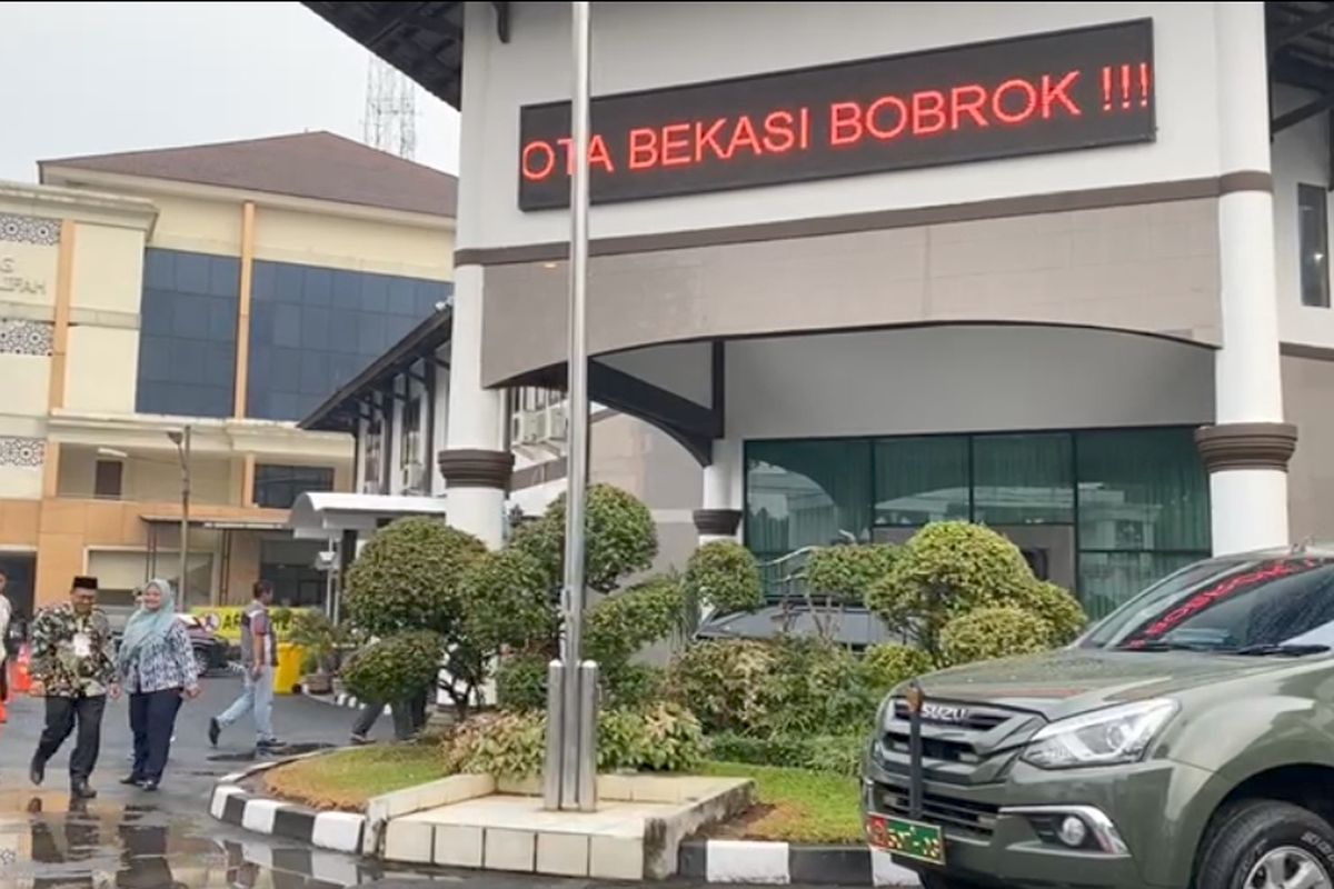 Running teks bertuliskan Plt Walikota Bekasi Bobrok!!!, yang mendadak terpampang di bangunan area halaman depan gedung Embarkasi Haji Jakarta-Bekasi, Kamis (25/5/2023).