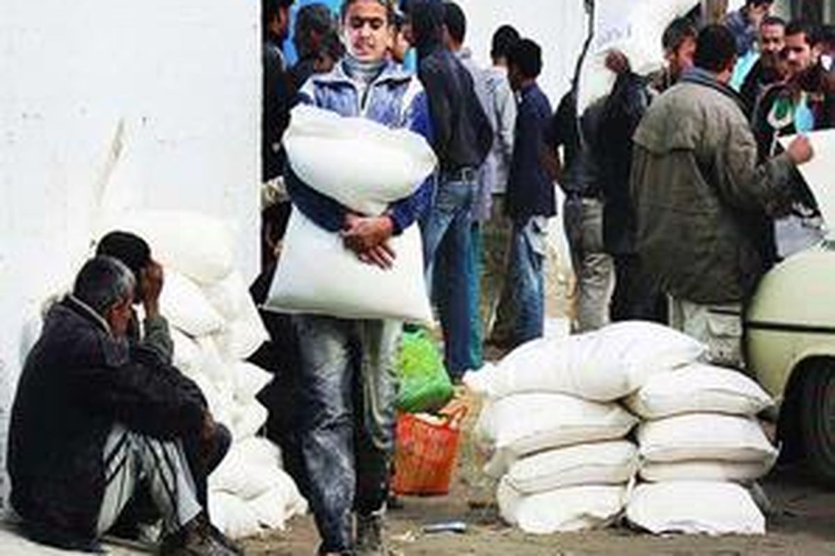 Seorang pemuda Palestina membawa satu karung tepung terigu yang diterimanya dari salah satu pusat pembagian bahan makanan PBB di Gaza City, Kamis (8/1). Warga Gaza kecewa karena PBB kemarin menghentikan sementara pemberian bantuan ke Jalur Gaza setelah sebuah tank Israel menewaskan dua warga Palestina di atas truk yang berbendera PBB