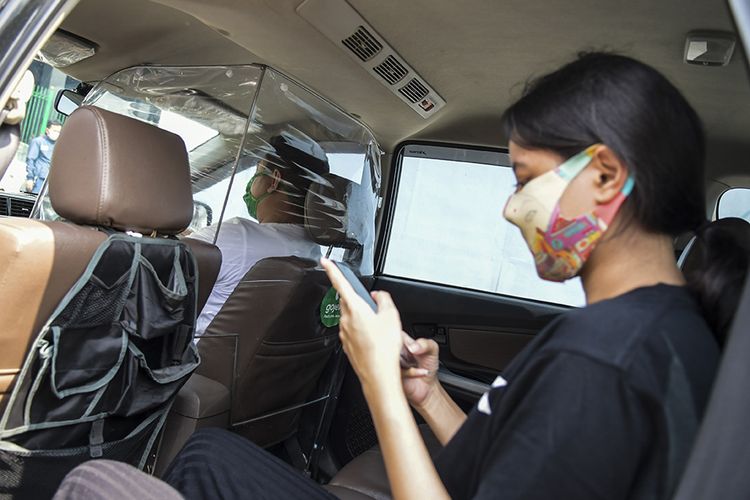 Penumpang menaiki taksi daring yang dipasangi sekat pelindung di kawasan jalan Kendal, Jakarta, Rabu (10/6/2020). Penggunaan sekat pelindung untuk pembatasan antara pengemudi dan penumpang tersebut sebagai bentuk penerapan protokol kesehatan guna meminimalisir risiko penyebaran virus COVID-19 dalam menghadapi era normal baru.