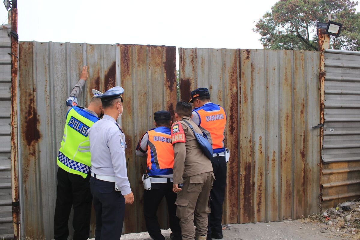 Dinas Perhubungan (Dishub)Kota Bandung bersama Satpol PP Kota Bandung didampingi Kepolisian dan TNI menutup paksa parkiran liar eks Palaguna Plaza di Jalan Asia Afrika, Kota Bandung, Jawa Barat, yang belakangan viral karena menetapkan karcis parkir sebesar Rp. 10.000 untuk sepeda motor