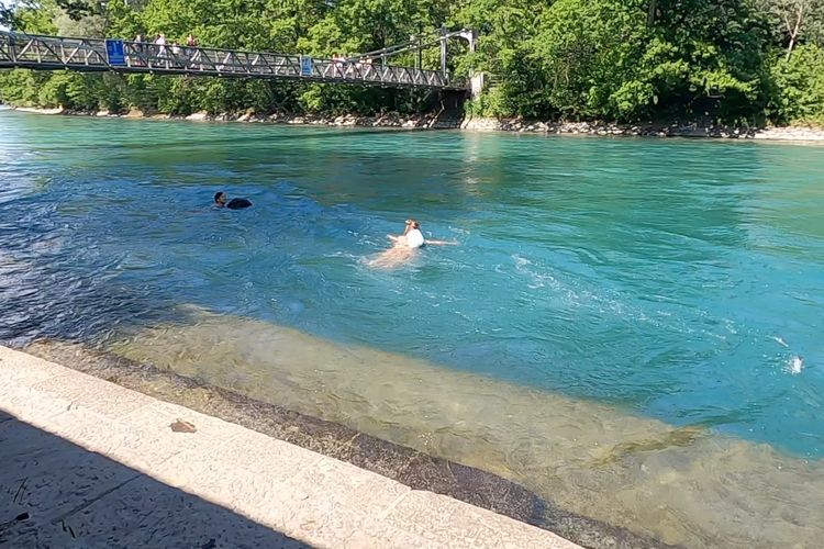 Dua orang Swiss berenang di Schoenausteg, lokasi yang menurut polisi Bern, Swiss menjadi tempat anak Ridwan Kamil, Emmeril Kahn Mumtadz atau Erill (23) mulai berenang di Sungai Aare, Selasa (31/5/2022) siang waktu setempat. Mereka berenang menggunakan dengan pelampung yang sekaligus menjadi tempat baju ganti.