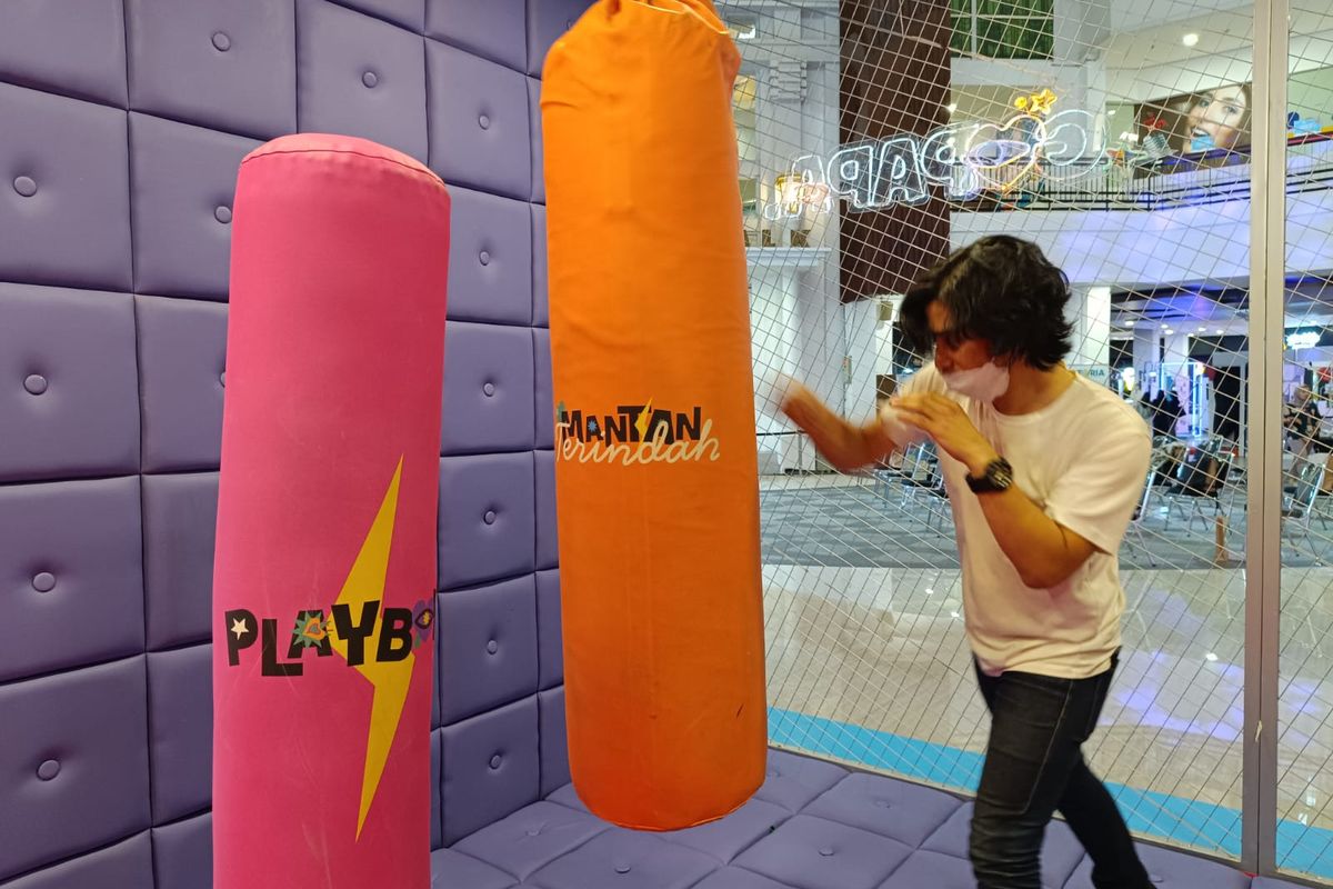 Seorang pengunjung memukul samsak bertuliskan Mantan Terindah di Museum Patah Hati Bandung, Senin (9/10/2023). Permainan ini bisa digunakan untuk melampiaskan emosi orang yang sedang patah hati. 