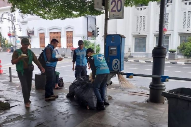 Petugas kebersihan saat bekerja membersihkan kawasan sekitar Alun-alun Kota Bandung Jawa Barat.  