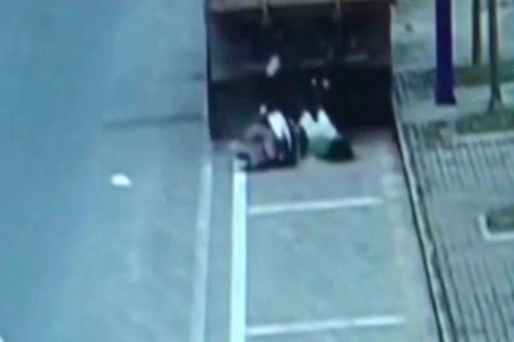 Foto yang diambil dari rekaman CCTV ini memperlihatkan seorang perempuan menabrak bagian belakang sebuah truk karena terlalu asyik main ponsel sambil mengendarai sepeda motor.