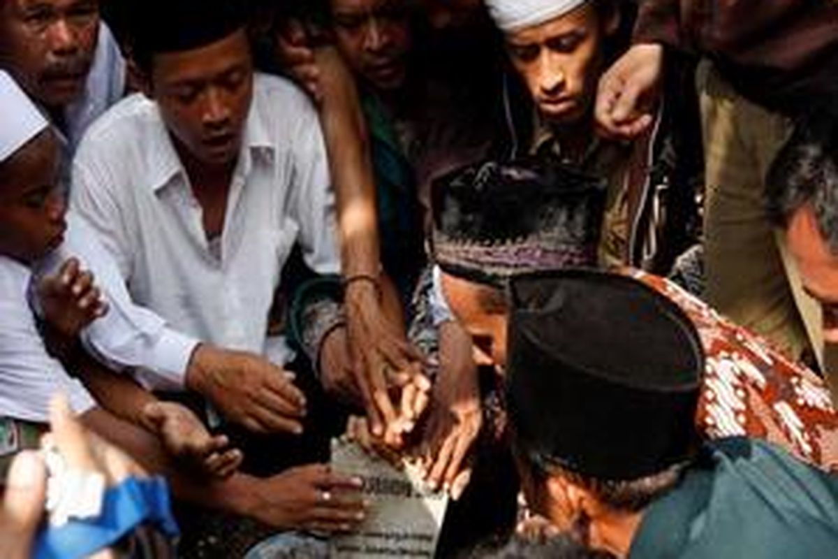 Warga berdesakan untuk mencium nisan makam Presiden ke-4 RI, KH Abdurrahman Wahid di Pondok Pesantren Tebu Ireng, Jombang, Jawa Timur, Kamis (31/12/2009).