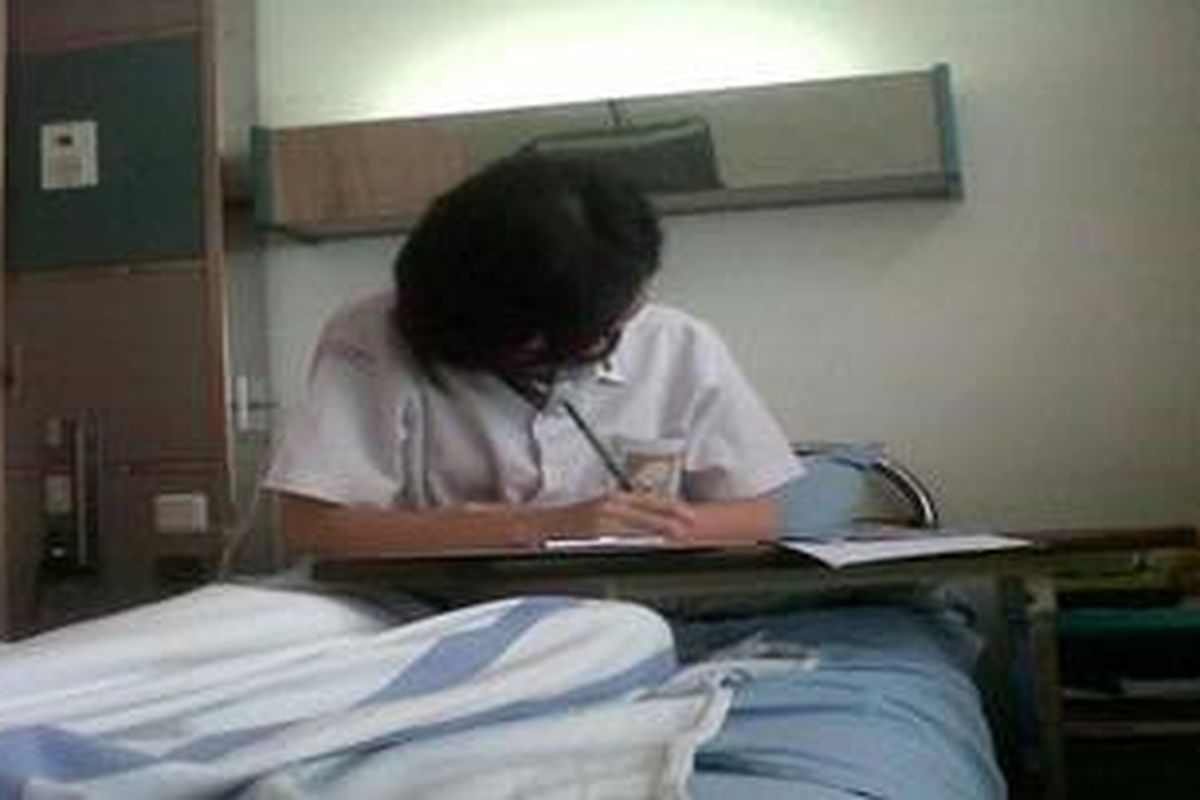 Stevani Christina Dewi (18) siswi SMA Krista Mitra tengah mengerjakan soal Ujian Nasional (UN) di Rumah Sakit Telogorejo, Senin (15/4/2013)