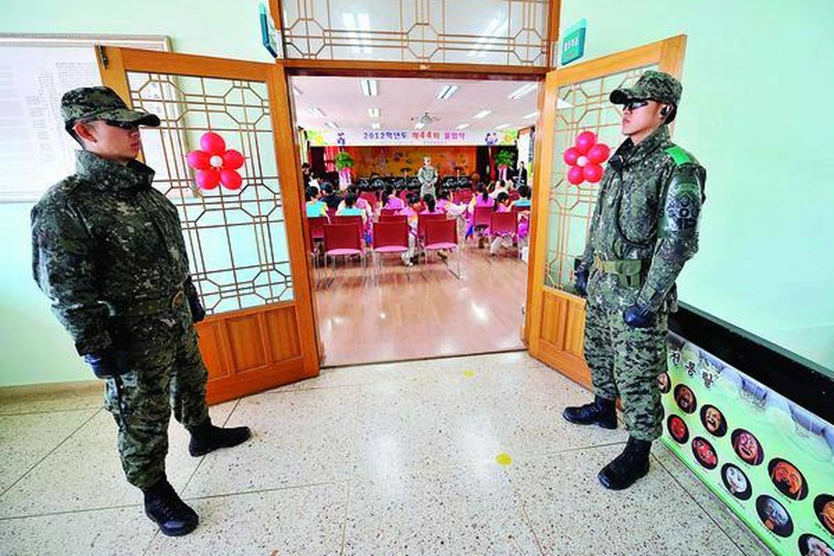 Dua prajurit Korea Selatan (Korsel) menjaga pintu masuk ruangan tempat upacara kelulusan siswa Sekolah Dasar Taesungdong di dekat Desa Panmunjom, desa perbatasan Korsel-Korea Utara (Korut) di Paju, Korsel, Jumat (15/2). Sekolah tersebut adalah satu-satunya sekolah yang terletak di zona demiliterisasi di antara kedua negara. 