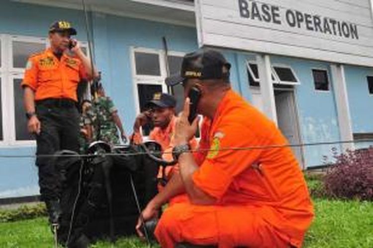 Anggota Basarnas menggunakan radio di pos komando Bandara Sentani, Jayapura, untuk berkomunikasi dengan tim SAR di lokasi jatuhnya pesawat Trigana Air di Oksibil, 18 Agustus 2015.