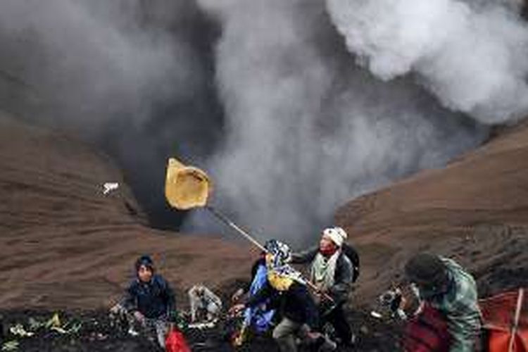 Warga luar Suku Tengger menangkap dengan jaring sesaji yang dilemparkan warga Tengger ke dalam kawah Gunung Bromo dalam puncak perayaan Yadnya Kasada di Kecamatan Sukapura, Kabupaten Probolinggo, Jawa Timur, Kamis (21/7/2016). Perayaan Yadnya Kasada sebagai ritual penghormatan leluhur dan wujud terima kasih warga Tengger atas hasil bumi tetap dilakukan walaupun Gunung Bromo berstatus Waspada.