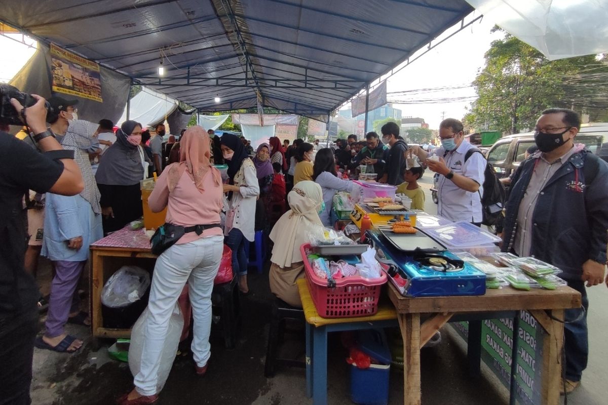 Sejumlah warga berbondong-bondong memadati tepi Jalan Bendungan Hilir, tepat di depan Pos Polisi, Tanah Abang, Jakarta Pusat, pada Senin (4/4/2022).   Mereka memadati sepetak lapak makanan beratap tenda biru yang biasa disebut pasar takjil menjelang berbuka puasa kedua di bulan Ramadhan 2022.