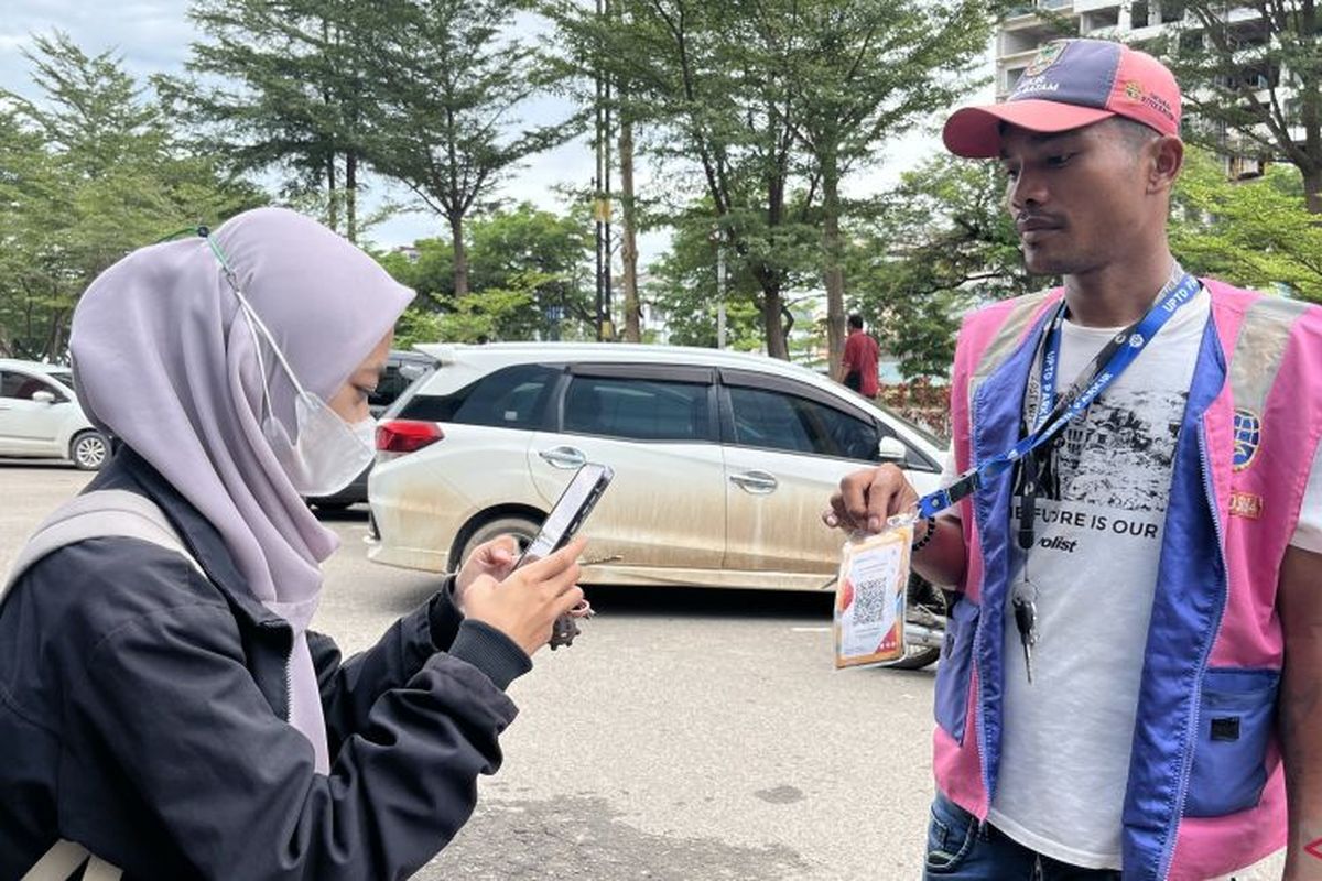 Ilustrasi pembayaran parkir melalui QRIS. Menko Airlangga menyebut bahwa transaksi pembayaran virtual melalui QRIS tidak dikenakan PPN 12 persen. 
