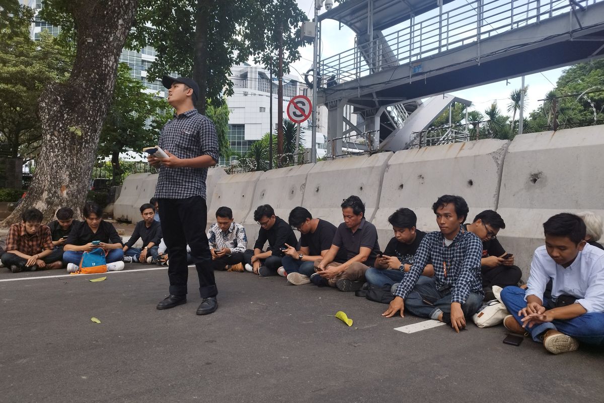 Mahasiswa membacakan puisi tentang demokrasi saat mimbar bebas Forum Anomali di Jalan Medan Merdeka Barat, Gambir, Jakarta Pusat, Jumat (2/2/2024).