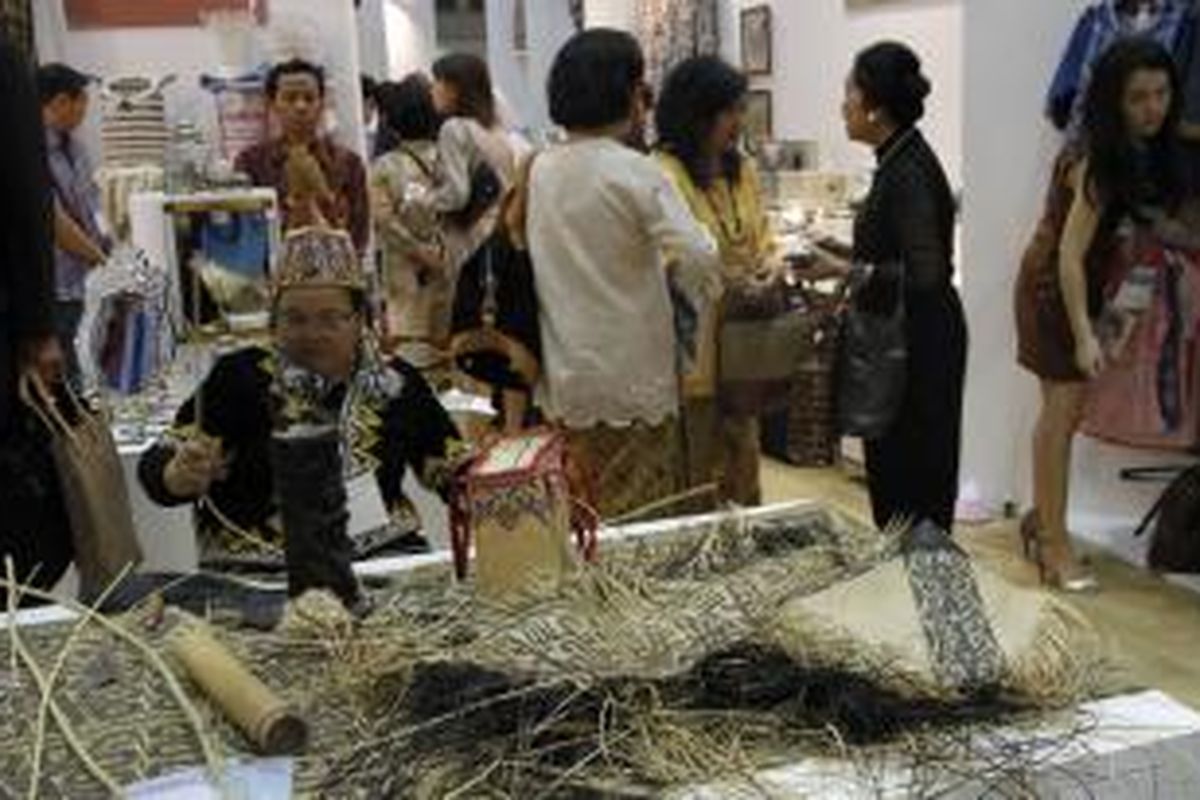 Seorang perempuan dayak mendemonstrasikan kerajianan anyaman di  Rumah Indonesia di Tokyo International Gift Show (TIGS), Tokyo, Rabu (4/9/2013). Sebanyak 36 perajin Indonesia yang diinisiasi oleh Dekranas berpartisipasi dalam pameran internasional ini. Jepang saat ini menjadi negara importir kedua terbesar barang kerajinan dan mebel asal Indonesia dengan nilai sekitar 1 miliar dollar AS untuk 2012.  