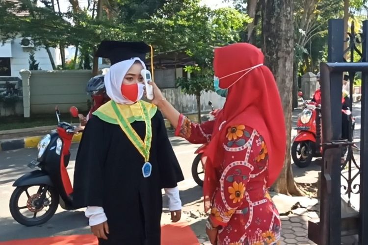 Salah satu anak didik MI Plus Walisongo Trenggalek, tengah dilakukan cek suhu badan oleh petugas, ketika dilaksanakan wisuda kelulusan tahun ini (28/06/2020).