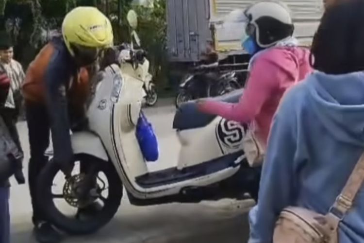 Pengendara rela angkat sepeda motor melalui trotoar agar bisa putar balik di Jalan Randugarut, Kecamatan Tugu, Kota Semarang, Jawa Tengah.
