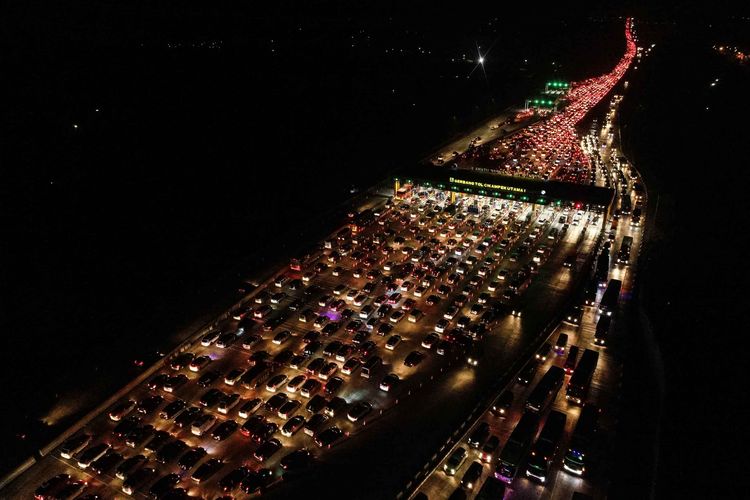 Foto udara kendaraan pemudik dari arah Jakarta melewati Gerbang Tol Cikampek Utama di malam hari di Cikampek, Jawa Barat, Sabtu (1/6/2019). Volume arus mudik dari arah Jakarta yang memasuki Gerbang Tol Cikampek Utama menuju ke sejumlah wilayah di Jateng dan Jatim pada H-4 siang hari terpantau padat merayap.