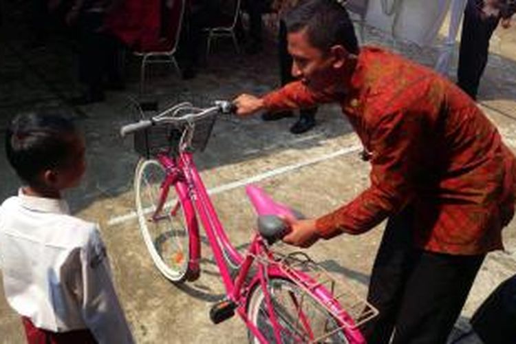 Seorang anggota Paspampres menyerahkan hadiah dari Presiden Jokowi kepada seorang siswa berupa sepeda dalam rangka kunjungan di SMP Negeri 4 Pontianak Timur 