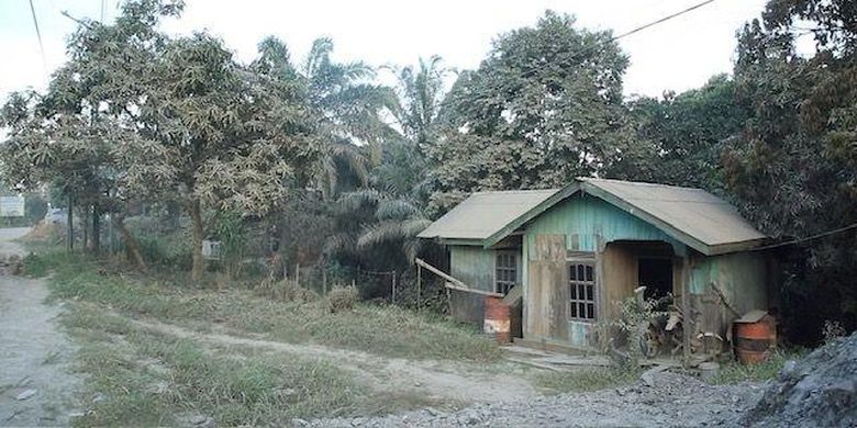 Rumah Sukini terletak persis di pinggir jalan raya yang menjadi akses kendaraan pengangkut material bangunan