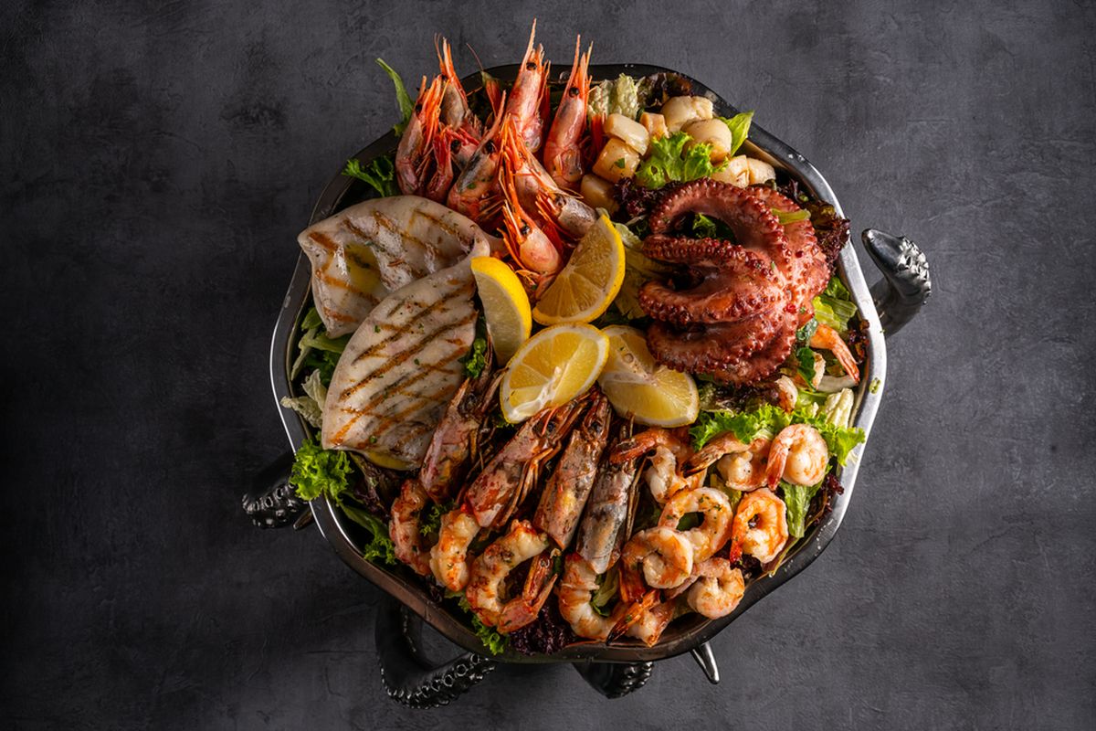 Ilustrasi seafood bakar terdiri dari kepiting, kerang, udang, cumi-cumi, dan ikan. 