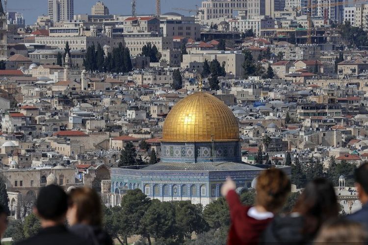 Wisatawan berdiri di Bukit Zaitun yang menghadap Kota Tua Yerusalem dan Kubah Batu di kompleks masjid al-Aqsa pada 18 Februari 2022.