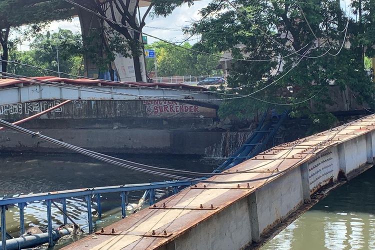 Pipa air bersih milik Perumda PAM Jaya yang ambruk di Kali Sunter, Plumpang Semper Raya, Koja, Jakarta Utara terlihat masih melintang di permukaan kali pada Senin (5/2/2024) pagi. 