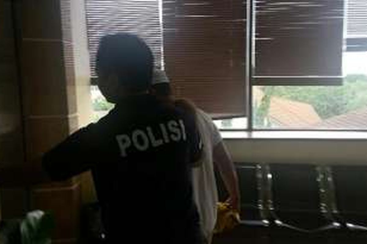 Pentolan Kalijodo Abdul Azis atau yang akrab disapa Daeng Azis bersama salah seorang anggota polisi seusai menjalani pemeriksaan terkait perdagangan perempuan di Polres Metro Jakarta Utara, Selasa (8/3/2016).