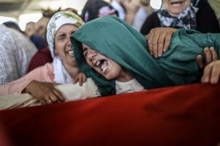 Sanak keluarga menangis saat upacara pemakaman korban di Gaziantep, 21 Juli 2015. 31 orang tewas dan ratusan terluka dalam peristiwa bom bunuh diri yang diduga dengan terkait Negara Islam Irak dan Suriah (ISIS).