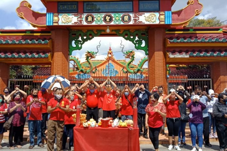 Puluhan umat Tri Dharma sedang memanjatkan doa di trotoar depan TITD Klenteng Kean Sing Bio Tuban di Hari Ulang Tahun Ke-1890 Kongco Kwan Sing Tee Koen. Kamis (14/8/2020) 