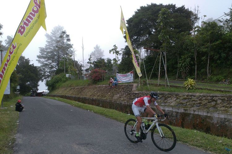 Pesepeda asal Jepang, Yasiki, ketika menyentuh garis finis dalam lomba dari Danau Mindanau - Kelok 44 dalam ajang MARS (Milagro Adventure Ride Series), Minggu (29/7/2018).