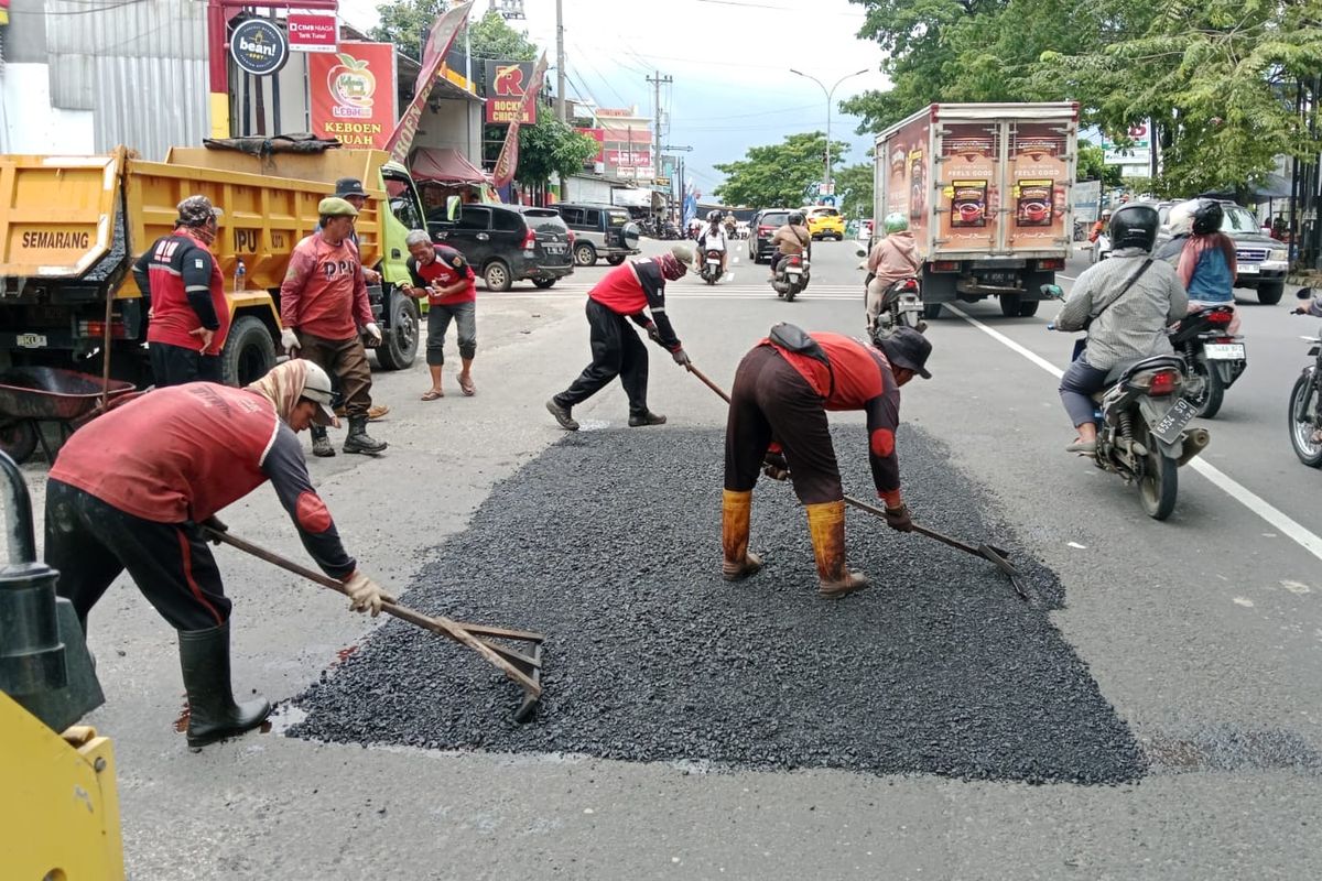 Petugas melakukan perbaikan jalan dengan metode tambal sulam (patching) menggunakan material hotmix di salah satu ruas jalan di Semarang.