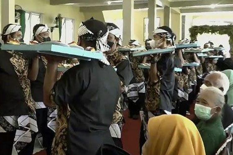 Para pramusaji menyajikan hidangan ke para tamu undangan di sebuah acara pernikahan di Kota Solo dengan tradisi piring terbang. 