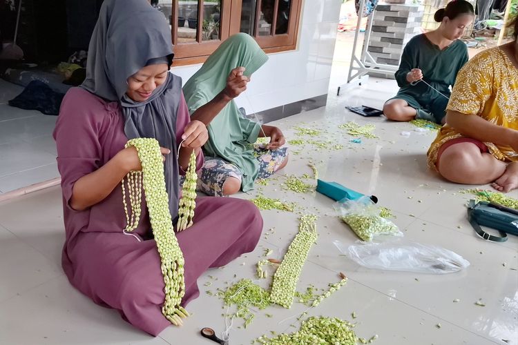 Pengrajin ronce melati di Dusun Bunalas, Kelurahan Tunjung, Kecamatan Burneh, Kabupaten Bangkalan, sedang membuat pesanan ronce pelanggannya, Jumat (13/6/2025). 