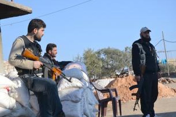 Pasukan pemberontak sedang berjaga di sebuah pos pemeriksaan di distrik Jabal al-Zawiya, Provinsi Idlib, Suriah. Selama empat hari terakhir pertempuran antara aliansi pemberontak melawan kelompok militan ISIL yang berafiliasi dengan Al Qaeda.