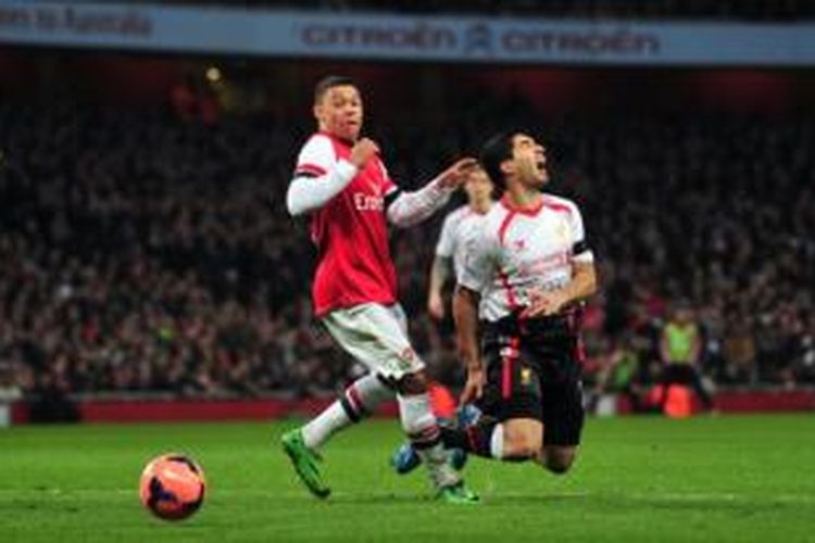 Gelandang Arsenal, Alex Oxlade-Chamberlain (kiri), mendapat jegalan dari striker Liverpool, Luis Suarez (kanan), pada laga Babak Kelima Piala FA di Stadion Emirates, London, Minggu (16/2/2014).