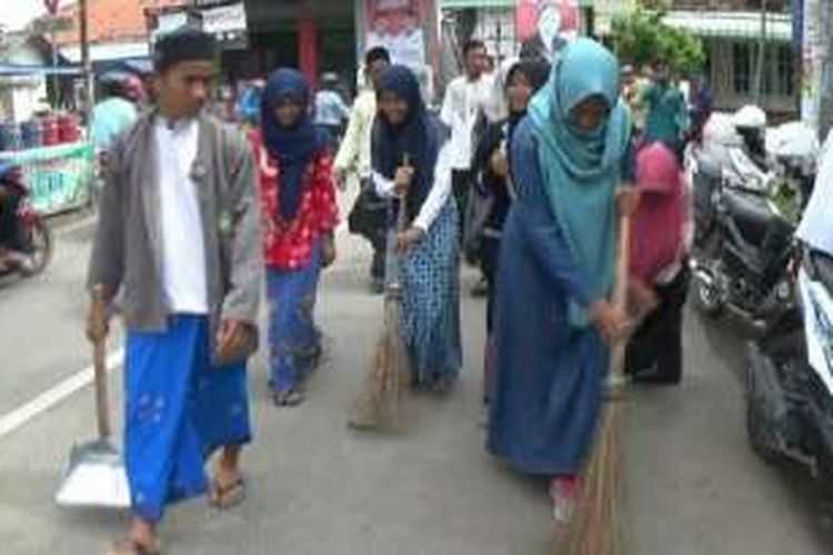 Siswa dan siswi MAN 1 Brebes, Jawa Tengah, melakukan aksi sosial memungut sampah di jalan dalam rangka hari santri nasional yang jatu pada 22 Oktober.